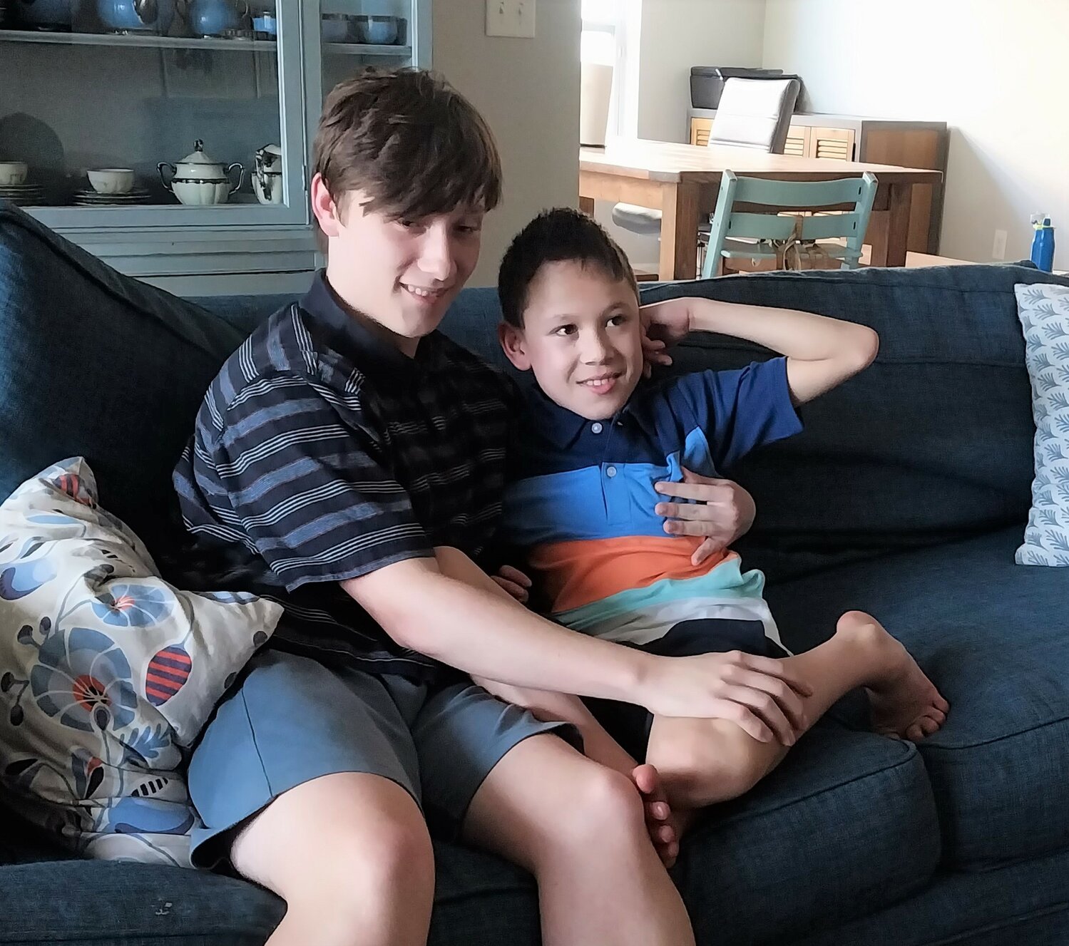 Jack Hilbert, left, and brother Calder sit on the living room sofa in the family’s Nocatee home.